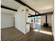 Open concept living area with wood floors, beamed ceilings, large windows, and a modern kitchen at 6261 Rassler Ave, Las Vegas, NV 89107