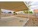Backyard view showing a covered patio area with a concrete slab and rock landscaping at 6388 Canyon Dawn Ave, Las Vegas, NV 89108
