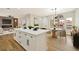 Bright, open kitchen featuring an island with white cabinets and a modern light fixture above the dining area at 6388 Canyon Dawn Ave, Las Vegas, NV 89108
