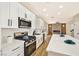 Modern kitchen with white cabinets, stainless steel appliances and a stone countertop breakfast bar at 6388 Canyon Dawn Ave, Las Vegas, NV 89108