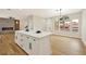 Bright, modern kitchen features an island with white cabinets, and an open view of the dining area and living room at 6388 Canyon Dawn Ave, Las Vegas, NV 89108