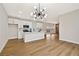 Open concept living and kitchen area with hardwood floors, modern lighting and white cabinets at 6388 Canyon Dawn Ave, Las Vegas, NV 89108