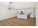 Open floor plan showing kitchen with white cabinets, center island, stainless steel appliances, hardwood floors, and modern lighting at 6388 Canyon Dawn Ave, Las Vegas, NV 89108