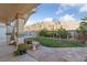Backyard featuring a lush lawn, mature landscaping, and mountain views at 6999 Stone Meadows Ave, Las Vegas, NV 89142