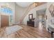 Bright foyer featuring a curved staircase, wood-look flooring, and a decorative entry door at 6999 Stone Meadows Ave, Las Vegas, NV 89142