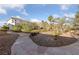 Beautiful landscaping surrounds the property with mature trees and a stone walkway leading to the house at 6999 Stone Meadows Ave, Las Vegas, NV 89142