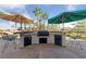 Outdoor kitchen with built in grill, bar seating, and shade umbrellas at 6999 Stone Meadows Ave, Las Vegas, NV 89142
