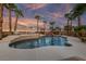 Inviting pool area with waterfall feature, seating, and palm trees creating a relaxing outdoor space at 6999 Stone Meadows Ave, Las Vegas, NV 89142