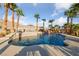 Inviting swimming pool with a waterfall feature, surrounded by palm trees and desert landscaping at 6999 Stone Meadows Ave, Las Vegas, NV 89142