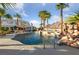 Stunning backyard pool with a waterfall feature and palm trees, offering a resort-like feel at 6999 Stone Meadows Ave, Las Vegas, NV 89142