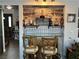 Stylish home bar featuring a glass shelf, designer backsplash, and seating for entertaining guests at 7400 Amigo St, Las Vegas, NV 89123