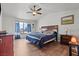 Spacious bedroom with wood floor, ceiling fan, blue linens, and a window to the backyard at 7400 Amigo St, Las Vegas, NV 89123
