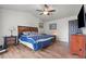 Vaulted bedroom featuring a ceiling fan, wood floors and a color coordinated bedspread and pillows at 7400 Amigo St, Las Vegas, NV 89123