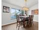 Bright dining room with wood floors, contemporary lighting fixture, and view to backyard pool at 7400 Amigo St, Las Vegas, NV 89123