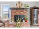 Close up of the brick fireplace with decorative mantle, gas insert, and ornamental plants at 7400 Amigo St, Las Vegas, NV 89123