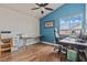 Office area featuring wood floor, a ceiling fan, bright blue accent wall and dual desk work spaces at 7400 Amigo St, Las Vegas, NV 89123