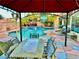Inviting outdoor patio with a dining area, overhead lighting, and a view of the pool and lush landscaping at 7400 Amigo St, Las Vegas, NV 89123