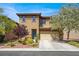 Charming two-story home with a two car garage, landscaped front yard, and blue front door at 7931 Mineral Peak St, Las Vegas, NV 89166