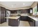 Well-equipped kitchen boasting stainless steel appliances, an island, and sleek dark cabinetry at 7931 Mineral Peak St, Las Vegas, NV 89166