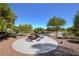 Park picnic table and grill, surrounded by desert landscaping and lush trees at 7931 Mineral Peak St, Las Vegas, NV 89166