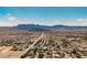 A wide aerial view showcases a sprawling community against a backdrop of majestic mountains at 7947 Lookout Rock Cir, Las Vegas, NV 89129