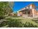 Inviting backyard featuring a covered patio with stone accents and a grill at 7947 Lookout Rock Cir, Las Vegas, NV 89129