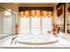 Bright bathroom with a soaking tub and three-section glass block window at 7947 Lookout Rock Cir, Las Vegas, NV 89129