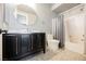Updated bathroom with a black vanity, stylish round mirror and custom tile floors at 7947 Lookout Rock Cir, Las Vegas, NV 89129