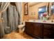 Charming bathroom with a tiled floor, shower with curtain, and wooden cabinets at 7947 Lookout Rock Cir, Las Vegas, NV 89129
