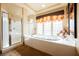 Bright bathroom with a soaking tub, glass block window, and separate shower at 7947 Lookout Rock Cir, Las Vegas, NV 89129