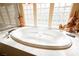 Close up on a soaking tub with jets and a three-section glass block window at 7947 Lookout Rock Cir, Las Vegas, NV 89129