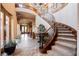 Grand foyer with spiral staircase, decorative table, tile flooring, and elegant lighting creates a welcoming entrance at 7947 Lookout Rock Cir, Las Vegas, NV 89129