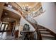 Elegant foyer with a winding staircase, chandelier, and marble-topped table offering a glimpse of luxury at 7947 Lookout Rock Cir, Las Vegas, NV 89129