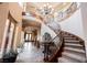 Elegant foyer with a spiral staircase, a striking chandelier, tiled floors, and decorative accents at 7947 Lookout Rock Cir, Las Vegas, NV 89129