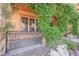 Inviting front porch featuring climbing plants, decorative wrought iron railing, and a cozy, shaded entrance at 7947 Lookout Rock Cir, Las Vegas, NV 89129