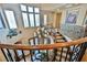 Elegant curved staircase with wrought iron railing and chandelier, leading to a bright landing with large windows at 7947 Lookout Rock Cir, Las Vegas, NV 89129