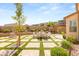 Beautiful backyard patio with built-in fireplace, lush landscaping, dining area, and mature trees at 812 Stannard Ct, Henderson, NV 89052