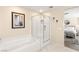 Well-lit bathroom with a bathtub, a glass-enclosed shower, and a doorway to the bedroom at 812 Stannard Ct, Henderson, NV 89052
