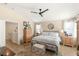 Comfortable bedroom featuring hardwood floors, a ceiling fan, a dresser and tv, and ensuite bath at 812 Stannard Ct, Henderson, NV 89052
