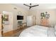 Comfortable bedroom featuring hardwood floors, a ceiling fan, a dresser and tv, and ensuite bath at 812 Stannard Ct, Henderson, NV 89052