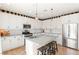 Modern kitchen featuring white cabinets, granite countertops, stainless steel appliances, and a kitchen island with stool seating at 812 Stannard Ct, Henderson, NV 89052