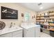 Well-organized laundry room with modern washer and dryer, sink, and ample shelving for storage at 812 Stannard Ct, Henderson, NV 89052