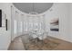 Elegant dining room featuring modern white chairs, a glass table set, and large windows with stylish curtains at 8130 Cassian Ct, Las Vegas, NV 89129