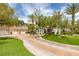 Expansive driveway leading to a well-maintained home featuring lush landscaping, mature trees, and a spacious three-car garage at 8130 Cassian Ct, Las Vegas, NV 89129