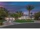 Stunning exterior of the home featuring a circular driveway, multiple garages, palm trees, and beautiful landscaping at 8130 Cassian Ct, Las Vegas, NV 89129