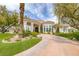 Stunning single-story home featuring a circular driveway, manicured landscaping, and a porte-cochere, showcasing its grand curb appeal at 8130 Cassian Ct, Las Vegas, NV 89129