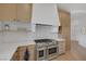 Well-equipped kitchen with professional-grade range, custom hood, tile backsplash, and custom cabinets at 8130 Cassian Ct, Las Vegas, NV 89129