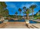 Resort-style pool featuring an island with palm trees, rock features, and lush landscaping creating a serene backyard oasis at 8130 Cassian Ct, Las Vegas, NV 89129