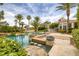 Stunning pool area boasting mature palm trees, beautiful landscaping, and a built-in bar at 8130 Cassian Ct, Las Vegas, NV 89129