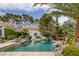 Gorgeous pool with rock features, steps into the water, and mature trees for privacy at 8130 Cassian Ct, Las Vegas, NV 89129